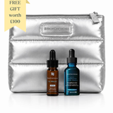 A silver metallic zippered pouch with a SKINCEUTICALS logo patch, displayed with two SKINCEUTICALS serum bottles in front on a white background. A yellow promotional ribbon in the top-left corner reads 'FREE GIFT worth £100'.