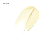 A textured swatch of creamy, pale yellow cosmetic product on a plain white background, with the word 'TEXTURE' printed in the upper left corner.