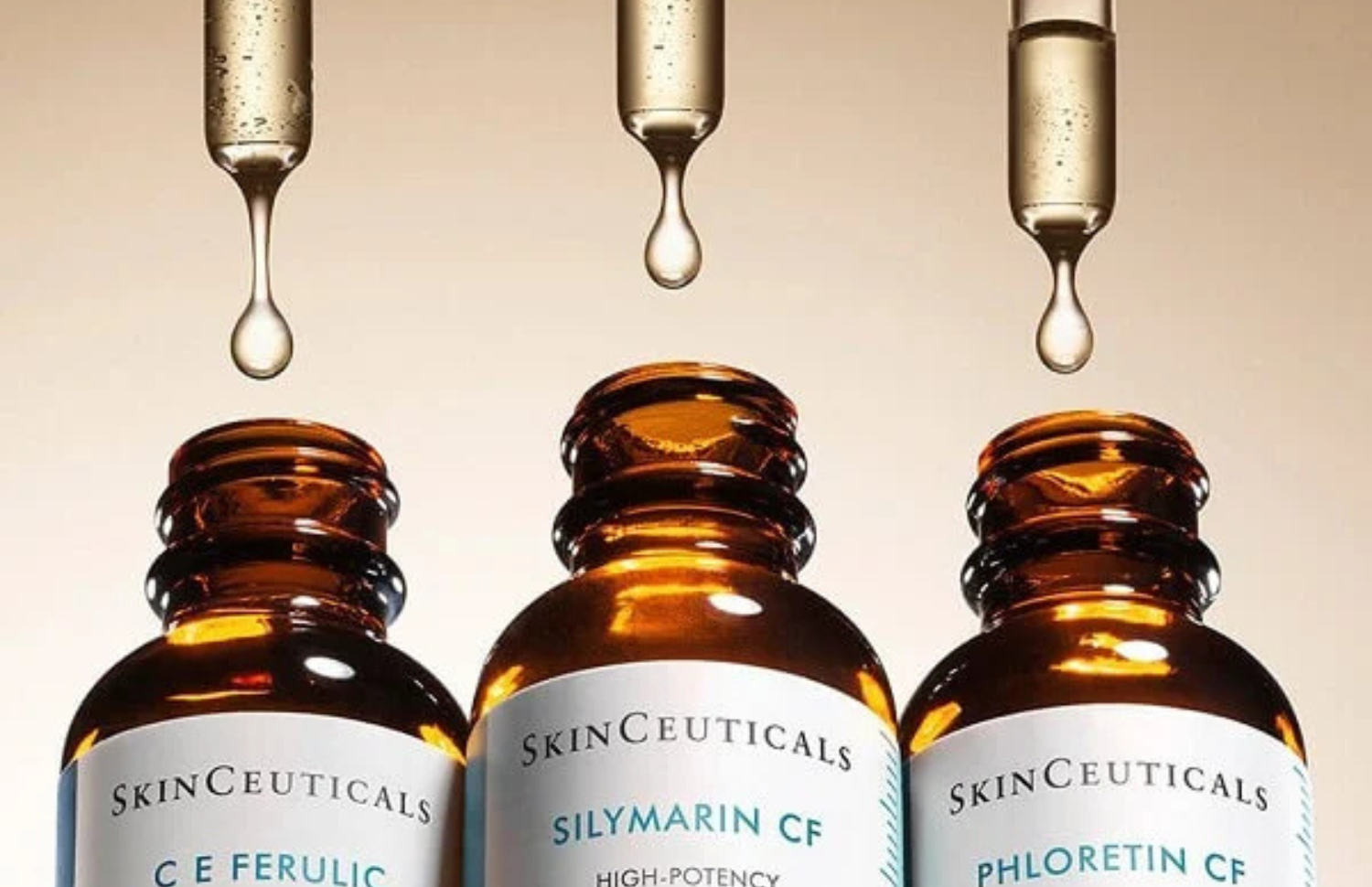 Three SkinCeuticals bottles with droppers and liquid dripping, on a neutral background.